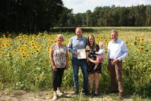 Eingerahmt von Niedersachsens Landwirtschaftsministerin Barbara Otte-Kinast (li.) und LJN-Präsident Helmut Dammann-Tamke (re.) erhielten Jan Heinrich Bührmann und seine Frau Isabell Bührmann aus Sögeln (Stadt Bramsche) (Mitte) das „Goldene Rebhuhn“,  eine Auszeichnung der Landesjägerschaft für Personen, die sich in besonderer Weise um den Erhalt der Natur in der Region verdient gemacht haben.