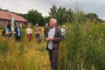 Johann Högemann, Obmann der Jägerschaft für Naturschutz der Jägerschaft Lingen und Wildpflanzenakteur der ersten Stunde erläutert den Teilnehmern die vielfältigen Vorteile des Anbaus von Wildpflanzen zur Energiegewinnung (Foto: © Carolin Könning)